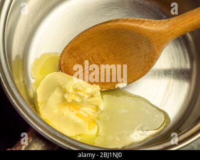 Melting non dairy spread with honey in a saucepan for use in making bread Stock Photo