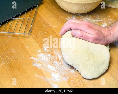 Kneading oat bread dough on a floured kitchen table Stock Photo