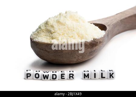 Full  fat powdered milk in wooden spoon isolated on white Stock Photo