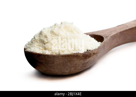 Full  fat powdered milk in wooden spoon isolated on white Stock Photo