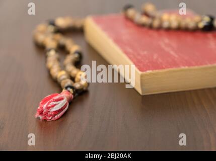Muslim prayer beads and Koran isolated on a wooden background. Islamic and Muslim concepts Stock Photo