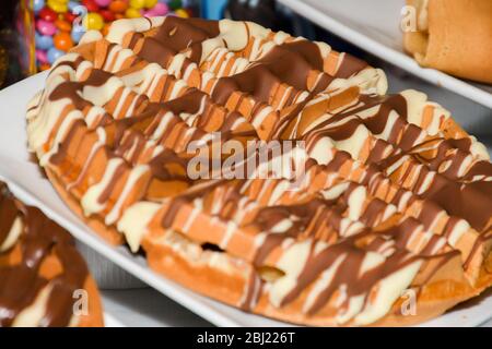 Waffles with white and dark chocolate topping, with fruits like strawberries and banana on top Stock Photo