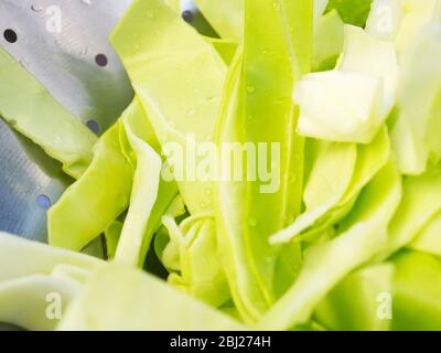 Washed fresh pointed cabbage slices in a stainless steel colander Stock Photo