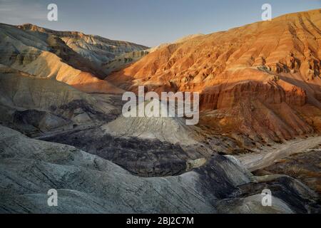 Bizarre layered mountains and Canyons at sunset in desert park Altyn Emel in Kazakhstan Stock Photo