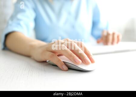 Female hand with computer mouse on table, closeup Stock Photo