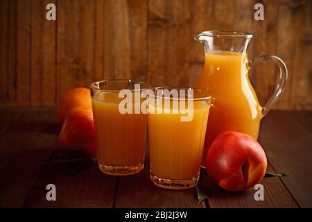 Peach juice and ripe peaches on wooden background Stock Photo