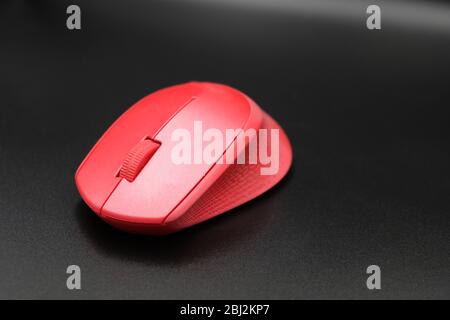 Isolated Red wireless optical mouse on black background. Stock Photo