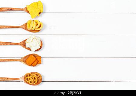 Mix of snacks : pretzels , crackers , chips and nachos on the table Stock Photo