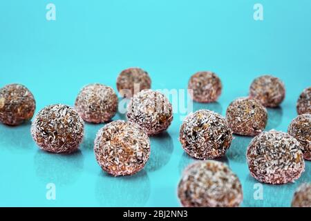Energy balls with oat, chocolate and coconut on blue green mint background. Healthy vegan and raw food diet. Proper nutrition concept. Selective focus. Copy space. Stock Photo