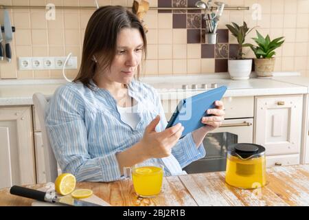 Female enjoys staying at home - watching movie, drinking tea Stock Photo