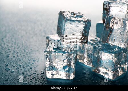 Melting ice cubes with drops around, close up Stock Photo