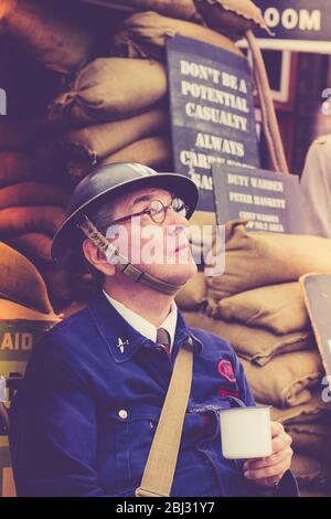 Retro close up of 1940 man as vintage, wartime ARP warden (air raid precaution) isolated at Severn Valley Railway station, 1940s WW2 summer event UK Stock Photo