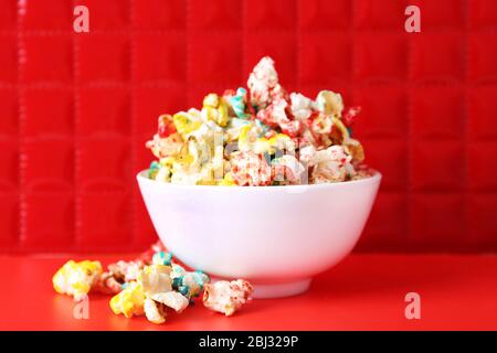 Sweet colourful popcorn on red background Stock Photo