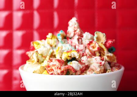 Sweet colourful popcorn on red background Stock Photo