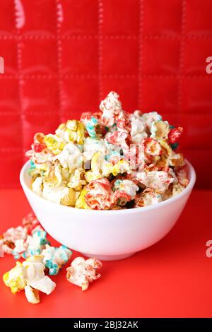 Sweet colourful popcorn on red background Stock Photo