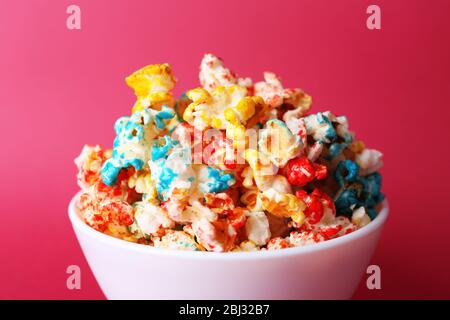 Sweet colourful popcorn on pink background Stock Photo