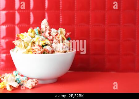 Sweet colourful popcorn on red background Stock Photo