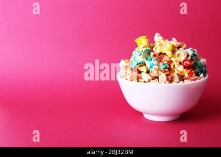 Sweet colourful popcorn on pink background Stock Photo