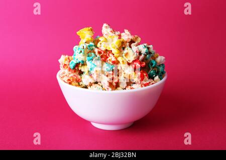 Sweet colourful popcorn on pink background Stock Photo