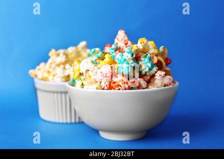 Sweet colourful and salted popcorn in bowls on blue background Stock Photo