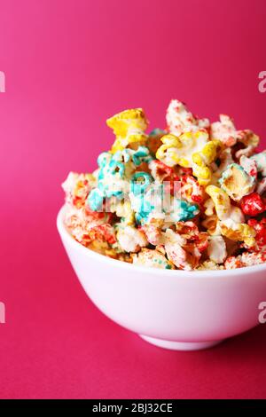 Sweet colourful popcorn on pink background Stock Photo