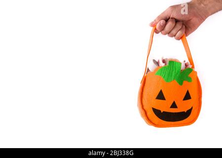 Hand holding Halloween pumpkin bag with candies inside isolated on white background Stock Photo