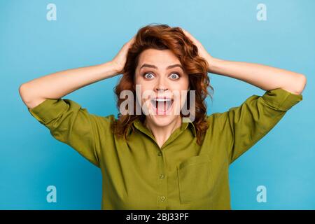 Portrait of astonished crazy woman hear wonderful ads promotion impressed scream shout touch head hands wear good look clothes isolated over blue Stock Photo
