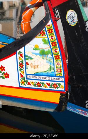 Traditional brightly painted gondola style moliceiro canal boat with saucy scene painted on prow in Aveiro, Portugal Stock Photo