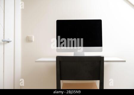 Computer with blank screen on the desk at home office. Working from home, isolation. Nobody Stock Photo