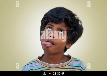 Rural boy making fanny face isolated on Color Background Stock Photo