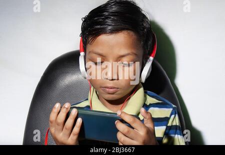 Boy with headphone watching movie on Smart phone Stock Photo