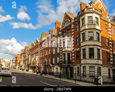 Red brick Victorian Buildings along Queen Anne’s Street in Marylebone, London, UK on a clear summers day Stock Photo