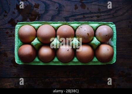 Ten raw farm chicken eggs in paper eco box on wooden background Stock Photo