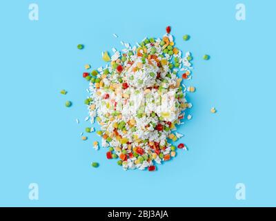 Frozen vegetables assorted on blue background. Assorted frozen vegetables food with ice, top view or flat lay. Raw uncooked frozen hawaii mix Stock Photo