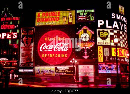 The neon signs of Piccadilly Circus in the West End of London advertising the popular products of the 1960s, taken in 1961. Stock Photo