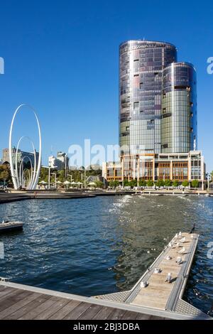 Carbon fibre sculpture Spanda by Christian de Vietri sculptor artist, Carlton Ritz Hotel and wooden jetty at Elizabeth Quay Perth Western Australia. Stock Photo