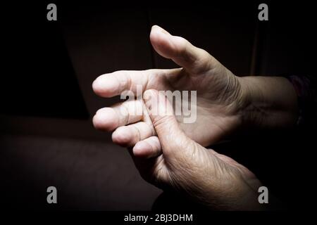 Hands of elderly woman doing a selfmassage. Manual physiotherapy Stock Photo