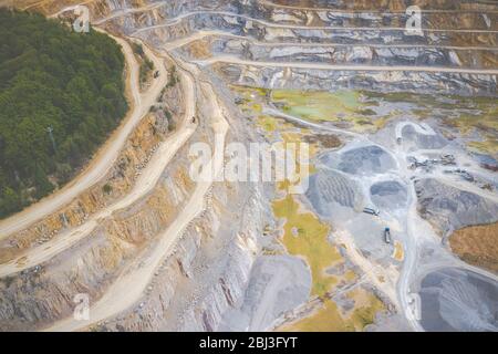 Mining from above. Industrial terraces on open pit  mineral mine. Aerial view of opencast mining. Dolomite Mine Excavation. Extractive industry. Giant Stock Photo