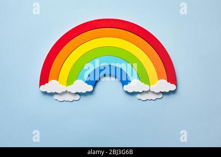 Vintage flat card with rainbow with white clouds on blue background. Chase the rainbow Stock Photo