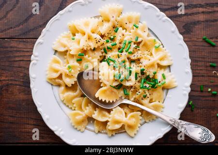 Hot homemade farfalle pasta with parmesan cheese sauce and chives Healthy Italian food Stock Photo
