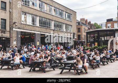 London/UK - 22/07/18: people eating and socialising in the Old Truman Brewery's Ely's Yard at Sunday UpMarket, one of 5 markets of  The Truman Markets Stock Photo