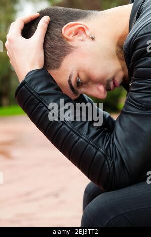 Young man with problems. Desperate men with hands on head. Close-up image of a handsome young man with hands on head. Thinking and thoughtful. Stock Photo
