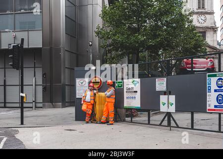 London/UK - 22/07/18: construction workers standing near gates to the costruction site on a street in the City of London Stock Photo