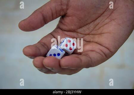 Adult holding the dices and ready to roll. Rolling out the dices Stock Photo