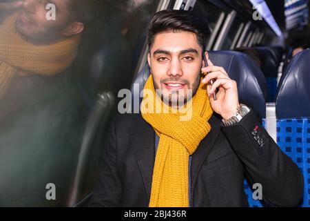 Businessman commuting to work on train using phone Stock Photo