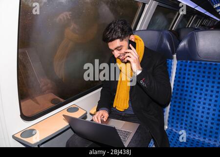 Businessman calls on phone and works on laptop Stock Photo