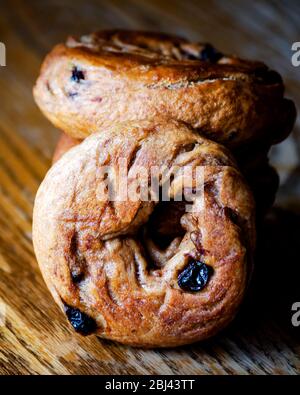 Dramatic lighting on a stack of homemade cinnamon raising bagels.  Close up view, blurry background. Stock Photo