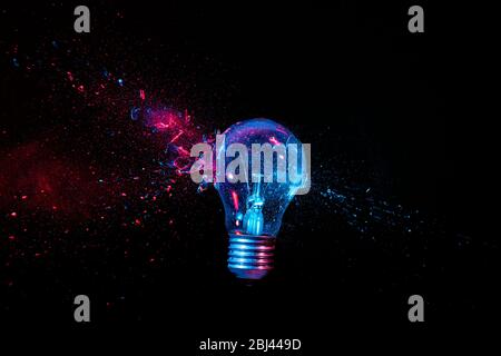 real explosion of a tungsten filament bulb. high speed photography. black background. concept of obsolete energy, crisis, fragility. Stock Photo