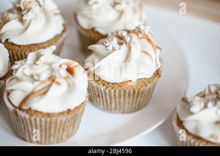 Beautiful white cupcakes on a white plate. Stock Photo