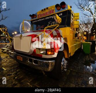 Liverpool, UK : Mar 16, 2019: An American style yellow school bus is used as a diner restaurant at the popular Royal Albert Dock tourist attraction in Stock Photo